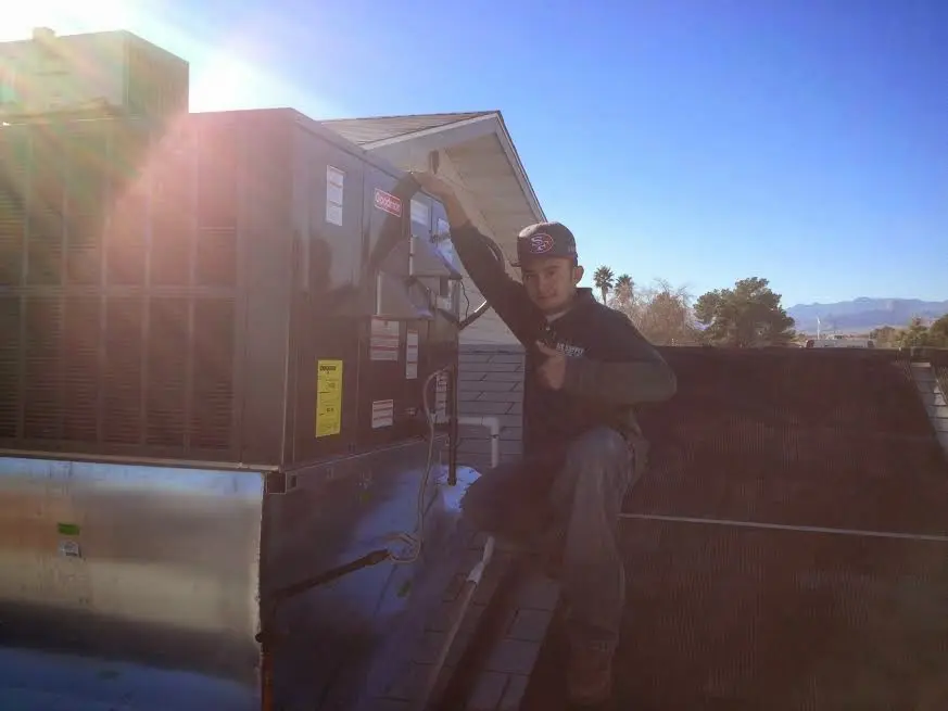 HVAC technician performing HVAC Inspection on a rooftop unit in Ruston